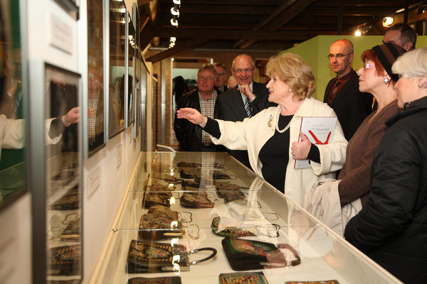 Frau Buresch zeigt Landrat Dr. Günther Denzler, Bürgermeister Jakobus Kötzner und den weiteren Gästen ihre Sammlerstücke