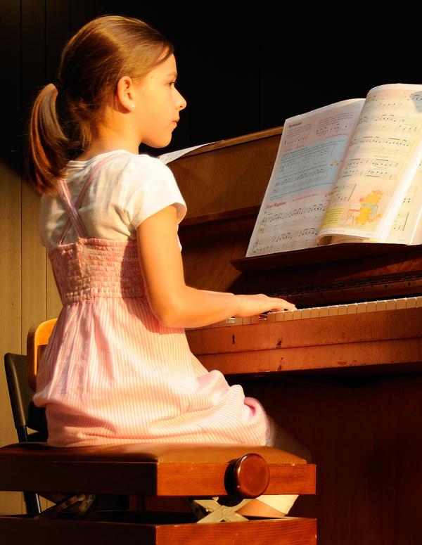 Ein Mädchen spielt am Klavier.