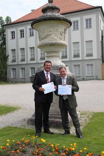 Bayerns Sozialstaatssekretär Markus Sackmann und Bayerns Finanzstaatssekretär Franz Josef Pschierer bringen am Eingang des Schlosses Nymphenburg in München das Schild »Wir machen mit« an.
