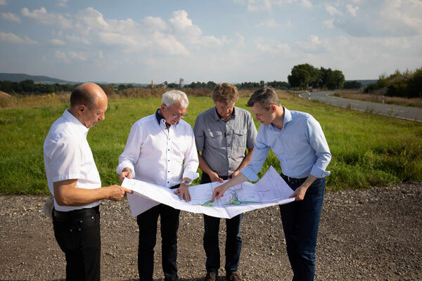 Landrat Johann Kalb, Staatssekretär Thomas Silberhorn und den Bürgermeistern Michael Karmann und Karl-Heinz Wagner begutachten die Planunterlagen für die neue Autobahnauffahrt für Altendorf.