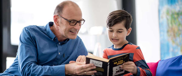 Lesepate unterstützt Kind beim Lesen lernen.