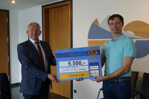 Der Präsident des Lions Club Bamberg-Michelsberg Volker Maisel übergibt Landrat Johann Kalb eine Spende von insgesamt 5.500 Euro für Kulturschaffende in Stadt und Landkreis Bamberg